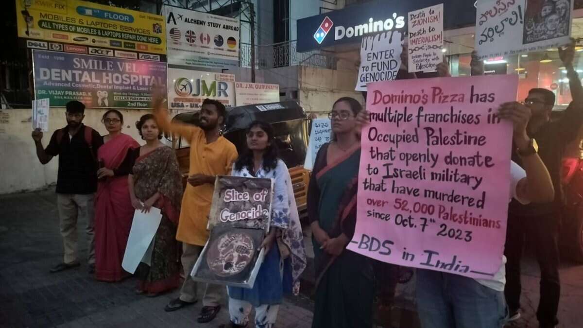 A group of protesters on May 10 stand outside a Domino’s outlet in India, holding signs in solidarity with Palestine. One sign reads,