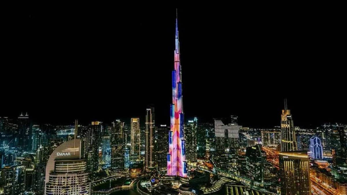 Night view of Burj Khalifa illuminated with colourful LED lights, surrounded by the glowing skyline of Downtown Dubai, UAE.