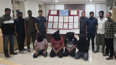 Four individuals, with black cloth bags over their heads, are kneeling in the foreground, indicating their arrest by the Hyderabad police on Tuesday, May 13, for their alleged involvement in a fake educational certificate racket.