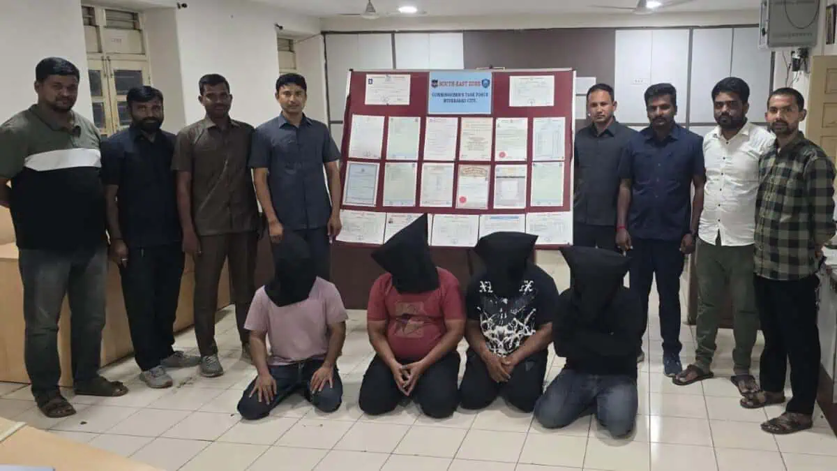 Four individuals, with black cloth bags over their heads, are kneeling in the foreground, indicating their arrest by the Hyderabad police on Tuesday, May 13, for their alleged involvement in a fake educational certificate racket.