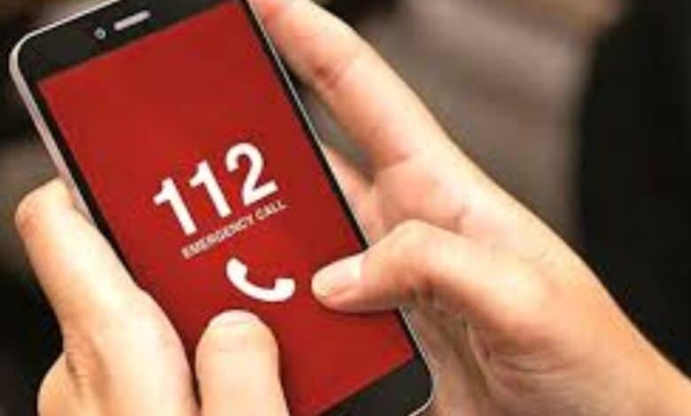 Image of man holding phone and dialing 112