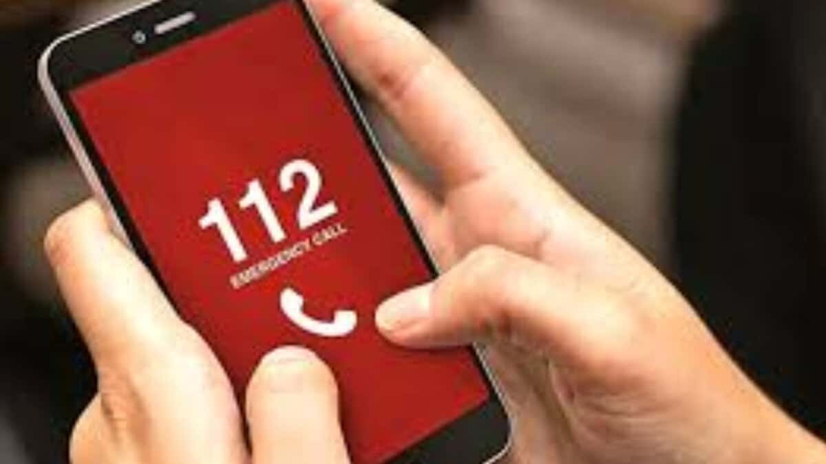 Image of man holding phone and dialing 112