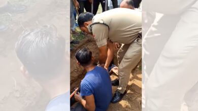 Image shows authorities intervening as BJP workers halt burial over disputed 'waqf land' in Uttarakhand; standoff intensifies after youths sit inside the dug grave.
