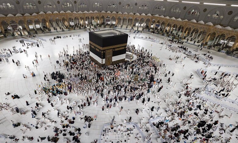 Pilgrims gather around the Holy Kaaba in Masjid al-Haram, Makkah, with the Kiswah partially raised and covered with a white cloth during the 1446 AH–2025 Hajj season as a precautionary measure.
