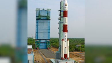 A PSLV-C6 rocket stands tall at SDSC SHAR, Sriharikota, ready for ISRO's 101st mission, with lush greenery and a clear sky in the background.