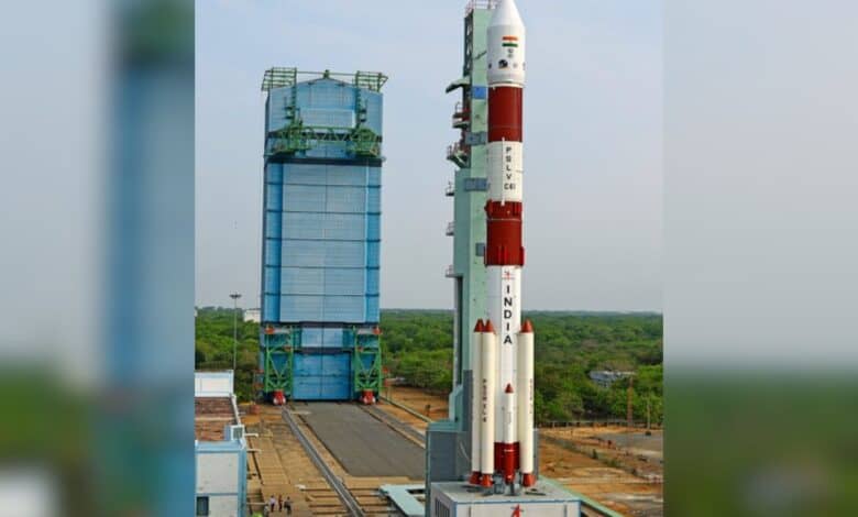 A PSLV-C6 rocket stands tall at SDSC SHAR, Sriharikota, ready for ISRO's 101st mission, with lush greenery and a clear sky in the background.