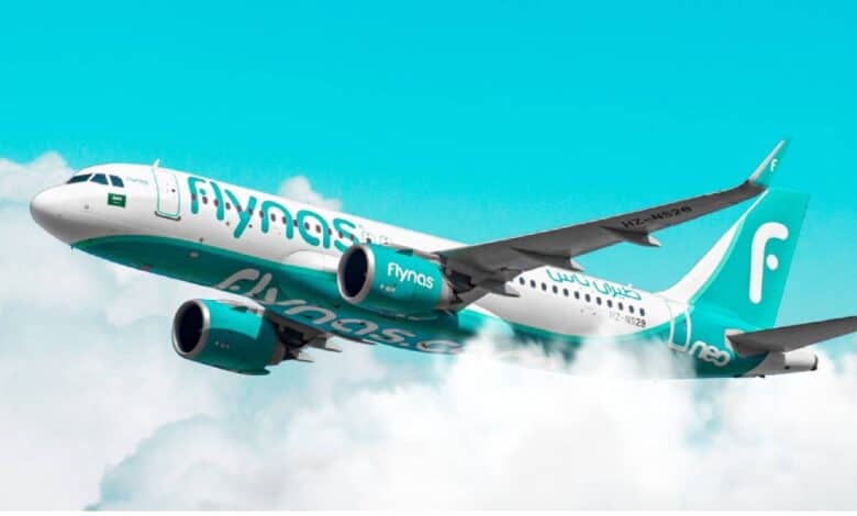 Flynas aircraft in flight above the clouds – Saudi Arabian budget airline.