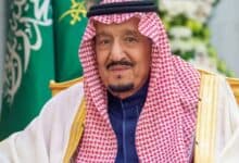Image of Saudi Arabia’s King Salman bin Abdul Aziz wearing traditional attire with Saudi flag in background.