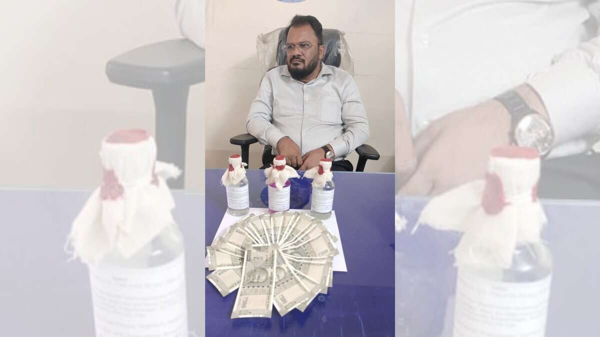 TGSPDCL Assistant Engineer sits at a desk with ₹10,000 bribe money laid out in front of him, moments after being caught red-handed by Telangana ACB officials in Pragathinagar.