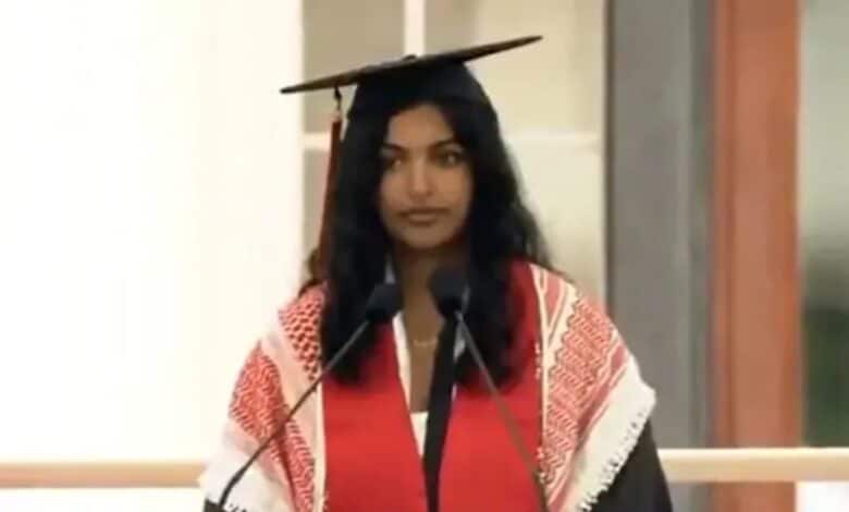 The image shows an Indian-origin MIT student wearing a red keffiyeh, a scarf symbolizing solidarity with Palestine, as she delivers her speech on the commencement stage during the graduation ceremony.