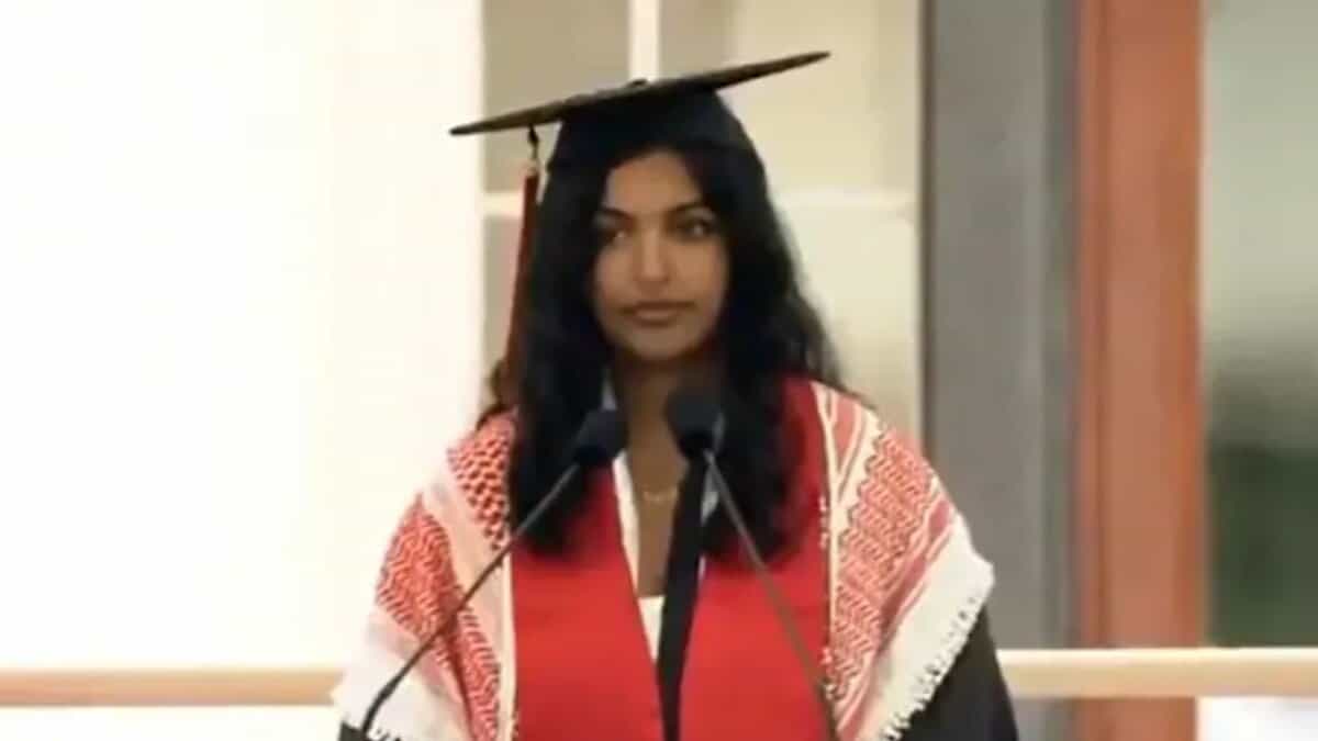 The image shows an Indian-origin MIT student wearing a red keffiyeh, a scarf symbolizing solidarity with Palestine, as she delivers her speech on the commencement stage during the graduation ceremony.