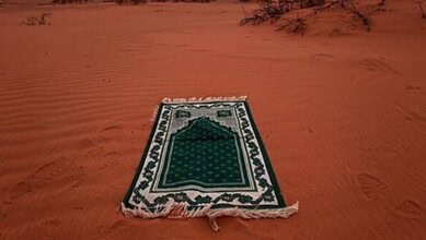 The image displays a green prayer carpet used for offering namaz