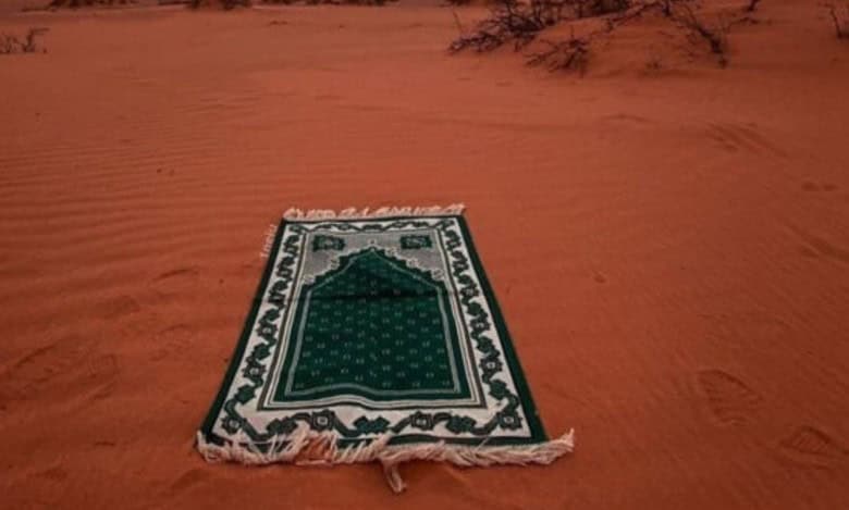 The image displays a green prayer carpet used for offering namaz