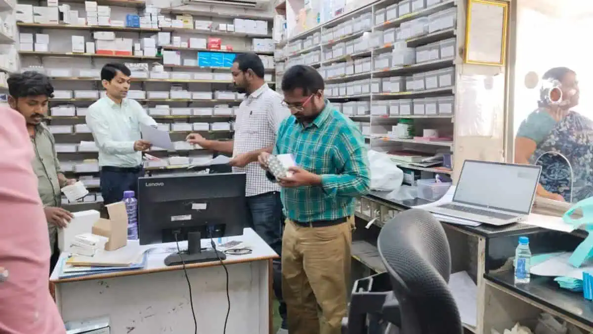 The image displays a picture of DCA officials conducting inspection at a pharmacy