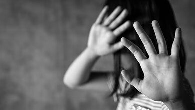 The photo displays a representational image of child abuse