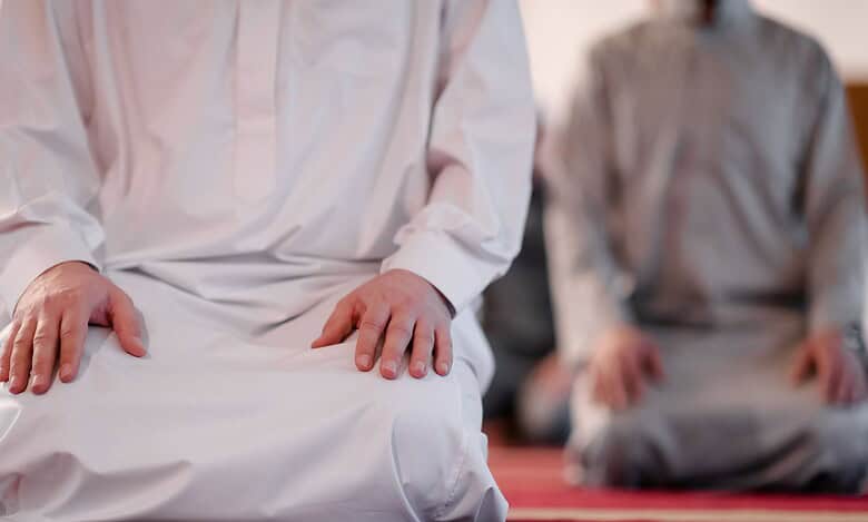 The image displays people offering namaz