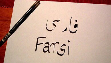 A white paper on wood with a red background shows "Fargi" in Persian (فارغی) and English, written in black ink in the context of the story Farsi Classes in Hyderabad.