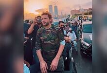 The image displays a picture of former cricketer Shahid Afridi participating in a 'victory' rally in Karachi