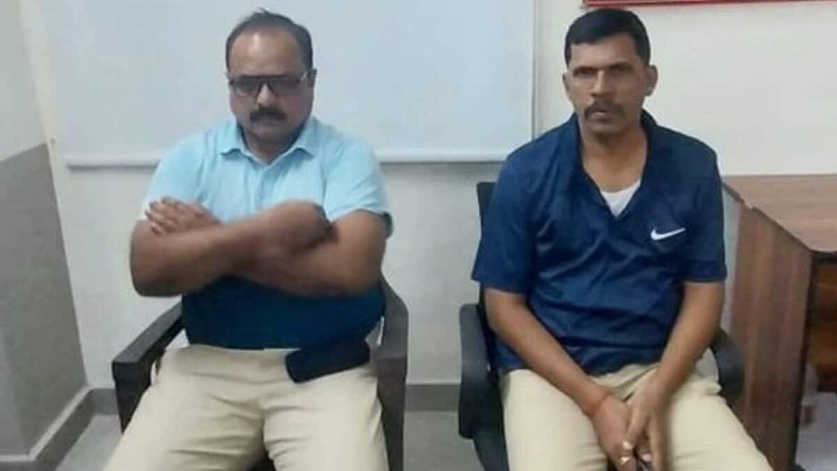 The image displays a picture of two Telangana police officers caught red handed for demanding bribe