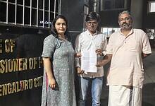 The image displays a picture of Alt News co founder and fact checker Mohammed Zubair in front of the office of Bengaluru police commissioner