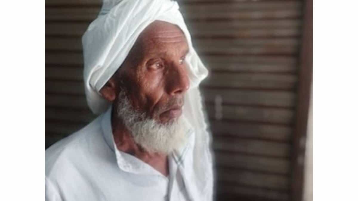 The image displays a picture of an elderly Muslim farmer