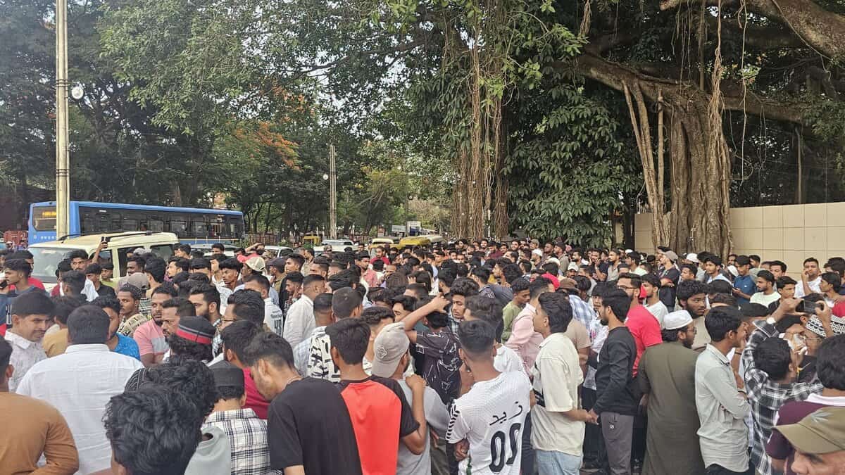 The image displays a picture of a large crowd protesting