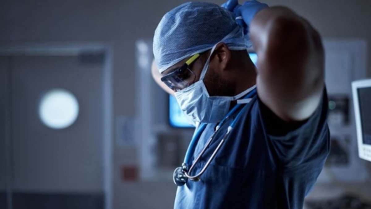 The image shows a picture of a doctor ready to conduct a surgery