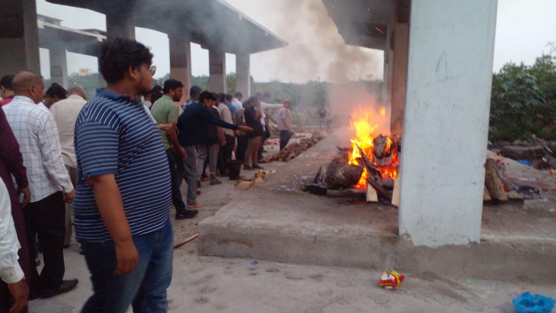 The image displays a funeral scene