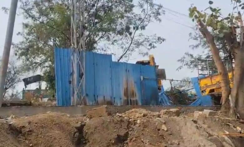 A bulldozer demolishes a make-shift shelter in Hydernagar