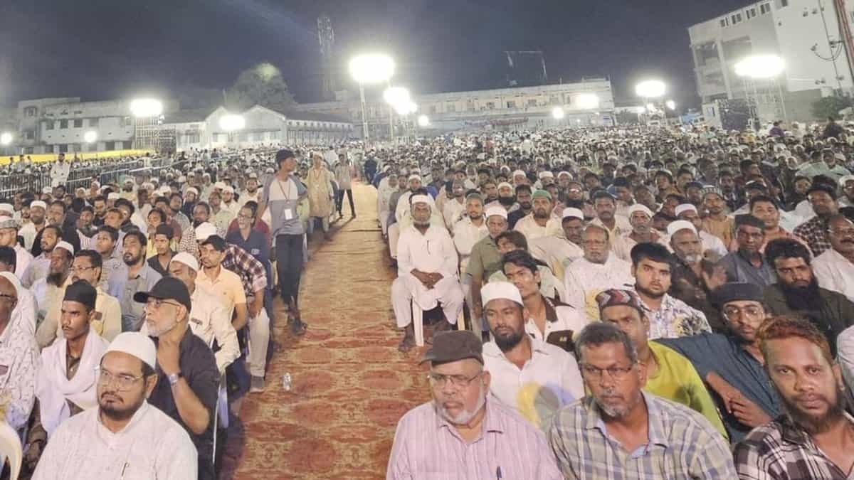 The image displays a large number of people participating in the Waqf Amendment Act protest in Warangal