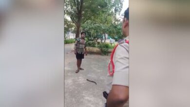 The image shows a man and a police officer. There is a sickle on the ground
