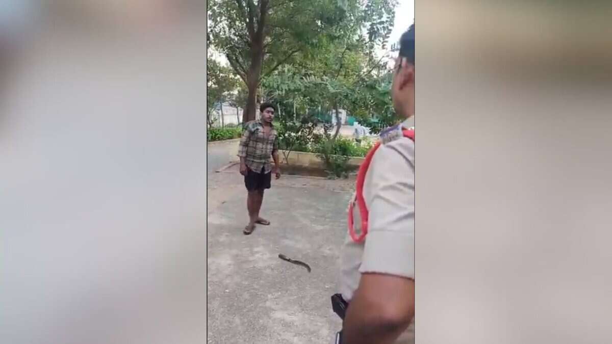 The image shows a man and a police officer. There is a sickle on the ground