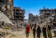 Civilians walk through rubble and destroyed buildings in Gaza after Israeli airstrikes, showing the humanitarian impact and devastation of conflict.