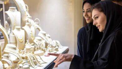 Two women in abayas admire gold jewellery displays at a shop in Dubai’s Gold Souk.