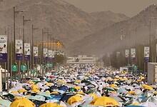 Pilgrims walk under colourful umbrellas during Haj 2024 in Saudi Arabia, braving the summer heat on their spiritual journey.
