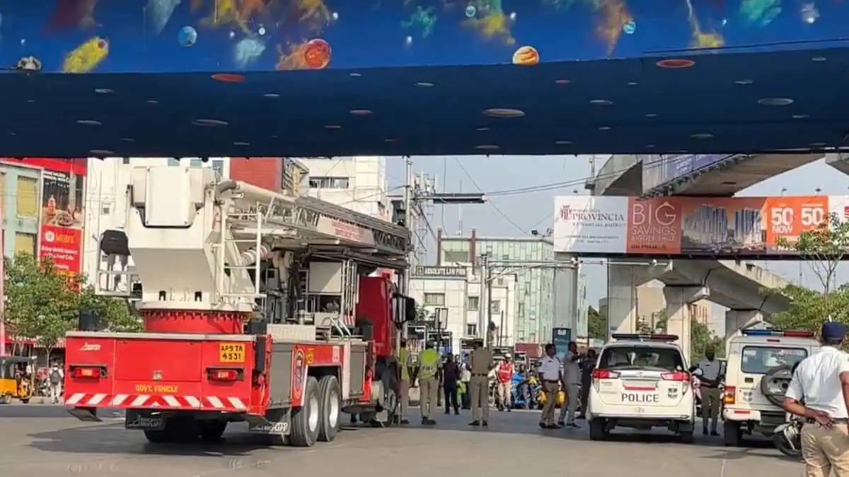 A scene at Cyber Tower Junction in Hyderabad during a mock air siren and civil defense drill. A fire truck with is parked on the left, while police vehicles and personnel manage the area