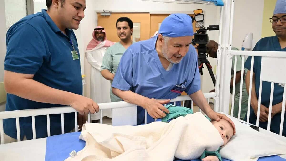 Mohammed Abdulrahman Juma, a Egyptian boy with a parasitic twin, lies in a hospital bed surrounded by a medical team in Saudi Arabia following a successful surgery.