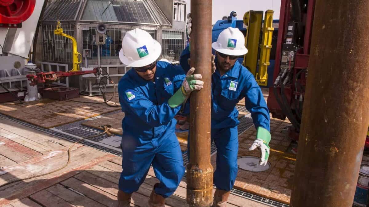 Saudi Aramco workers operate drilling equipment at an oil rig site.