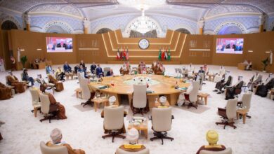 President Donald Trump attends a high-level Gulf Cooperation Council (GCC) summit in Riyadh, Saudi Arabia, alongside Gulf leaders and dignitaries. The ornate hall features flags of GCC member states and the United States, with a central roundtable discussion focused on regional security and Iran.