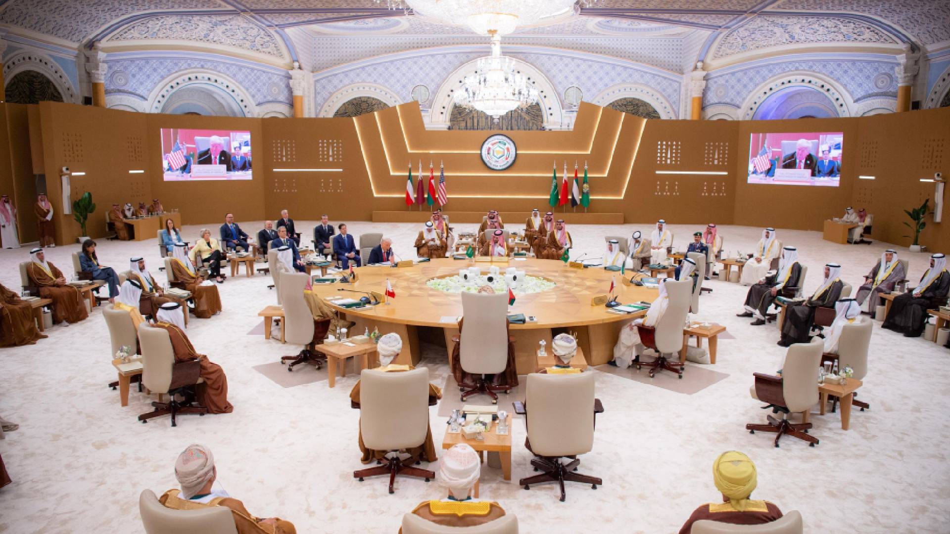 President Donald Trump attends a high-level Gulf Cooperation Council (GCC) summit in Riyadh, Saudi Arabia, alongside Gulf leaders and dignitaries. The ornate hall features flags of GCC member states and the United States, with a central roundtable discussion focused on regional security and Iran.