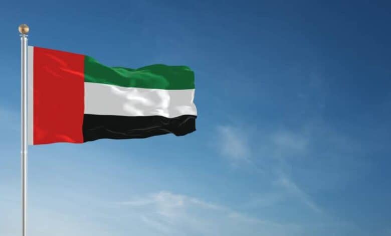 The national flag of the United Arab Emirates (UAE) waving against a clear blue sky, symbolising unity and national pride.