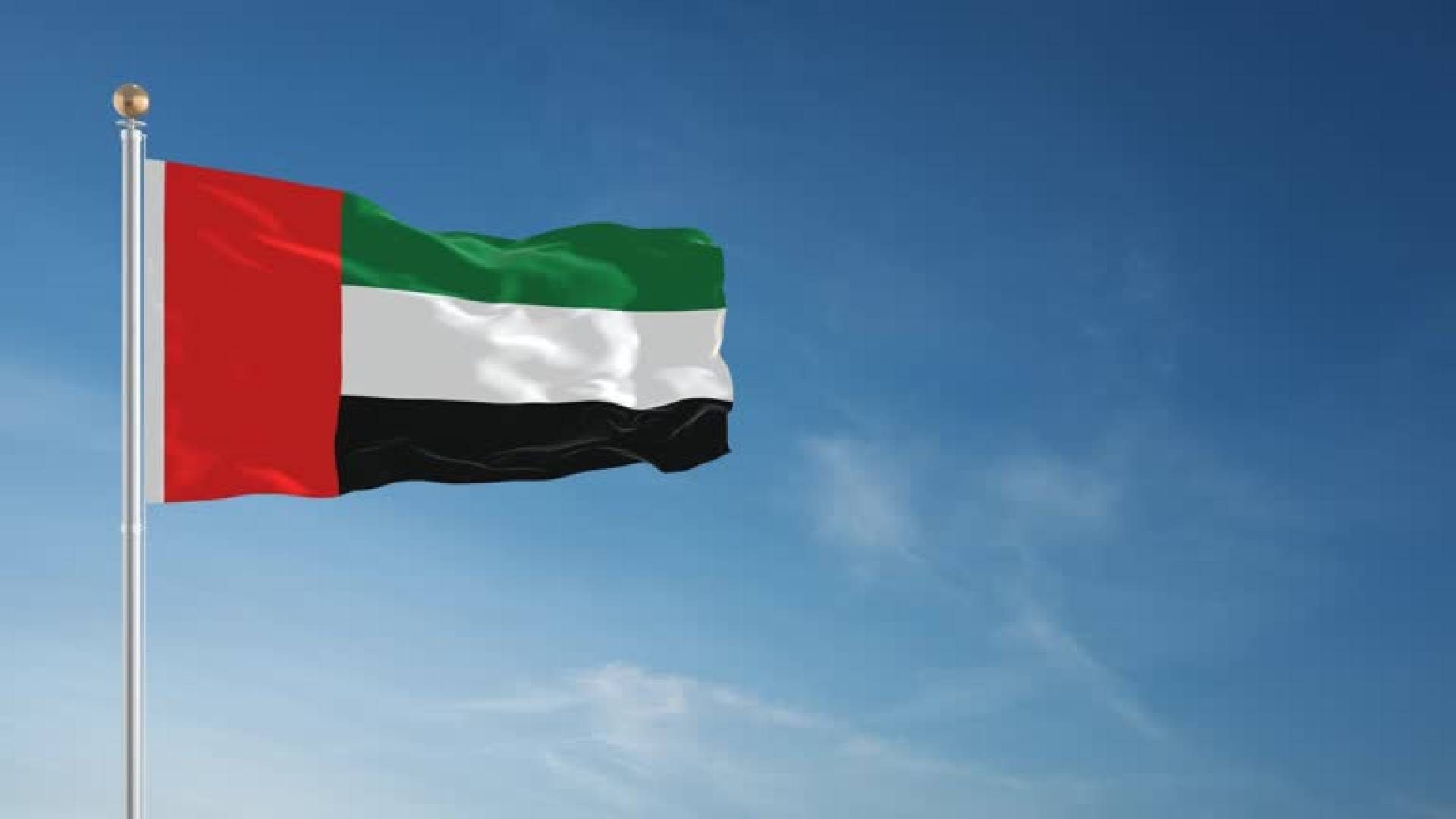 The national flag of the United Arab Emirates (UAE) waving against a clear blue sky, symbolising unity and national pride.