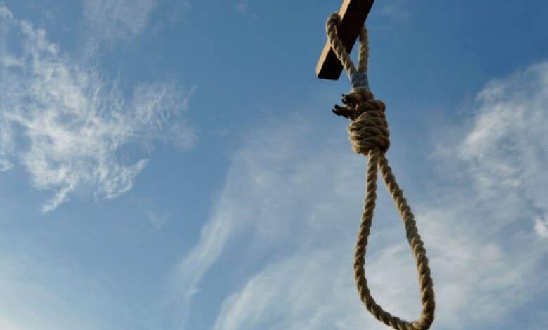 The image of a noose hanging from a wooden beam against a blue sky, symbolising execution.