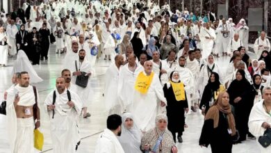 Muslim pilgrims walk through the Grand Mosque in Makkah ahead of Haj 2025, dressed in traditional Ihram clothing.