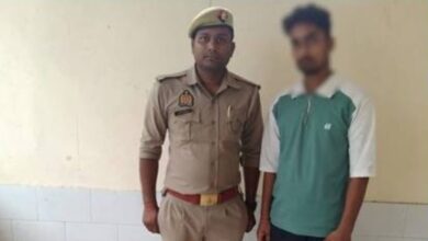 Image of the accused standing with Jaipur police official after being arrested for raping two minors.