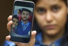 Pushpa Joshi, sister of Bipin Joshi, a Nepali man taken hostage by Hamas on Oct. 7, 2023, shows photos of them together during an interview with The Associated Press in Kathmandu, Nepal, Thursday, June 12, 2025. (AP Photo/Niranjan Shrestha)