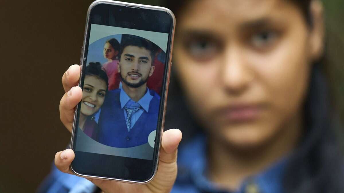 Pushpa Joshi, sister of Bipin Joshi, a Nepali man taken hostage by Hamas on Oct. 7, 2023, shows photos of them together during an interview with The Associated Press in Kathmandu, Nepal, Thursday, June 12, 2025. (AP Photo/Niranjan Shrestha)