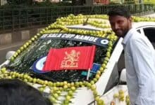 RCB fan poses next to car deocrated with Nimbu mirchi ahead of ipl final