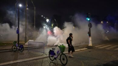 A man walks past tear gas during incidents after the Champions League final soccer match between Paris Saint-Germain and Inter Milan on Sunday in Paris.