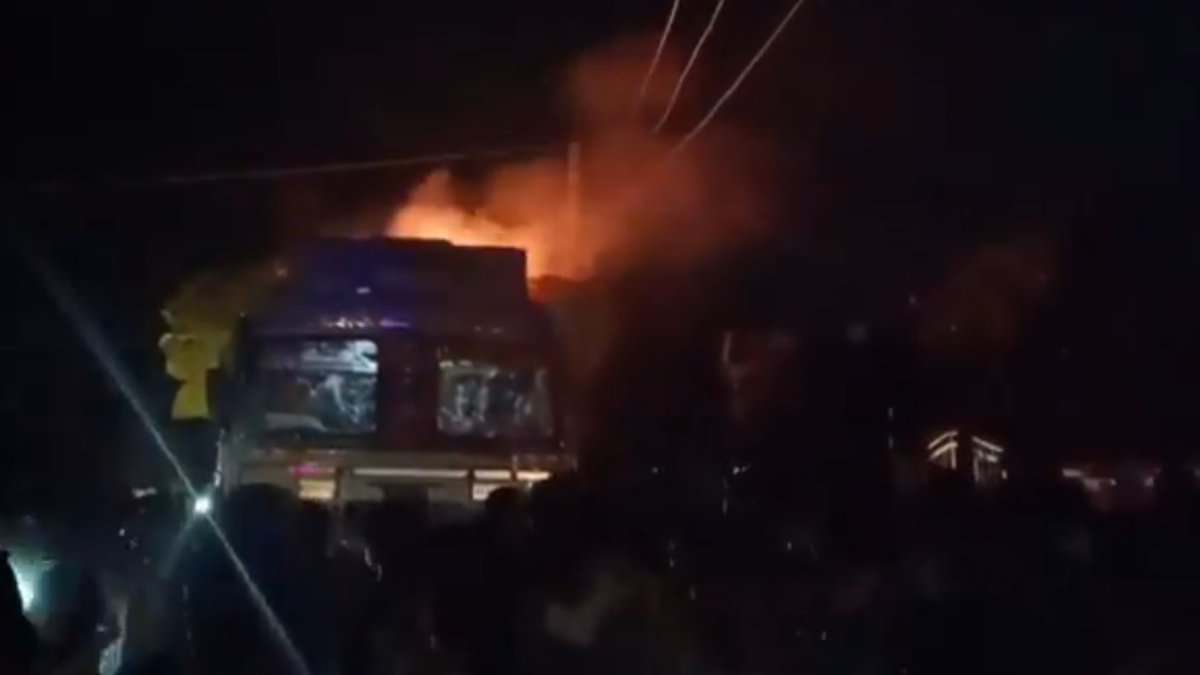 The image displays a picture of a Hindutva mob setting a truck in fire in UP
